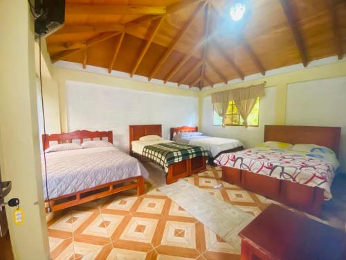 Zimmer mit 2 Betten und einem Tisch in der Unterkunft HOSTERIA SAN GERONIMO in Ibarra