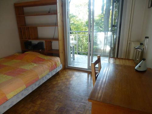 Schlafzimmer mit einem Bett und einer Glasschiebetür in der Unterkunft Spacious Condo, Green Serenity in Palaiseau