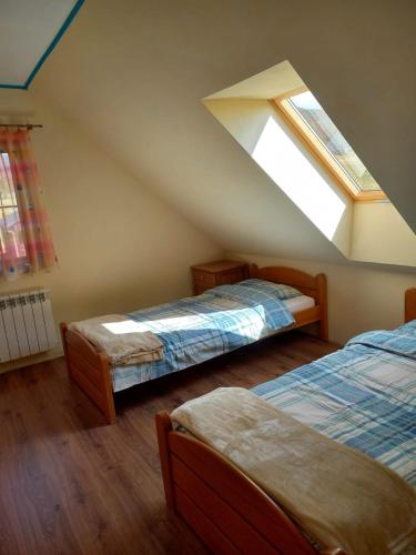 a attic room with two beds and a skylight at Słoneczne zbocze in Wysowa-Zdrój