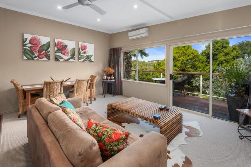 a living room with a couch and a table at Sanctuary Palms in Paihia
