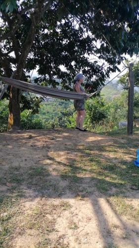 a woman holding a hammock under a tree at Loma Bonita in Lérida