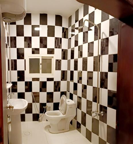 a bathroom with a black and white checkered wall at فندق البلد in Riyadh
