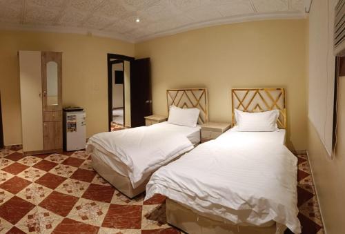 2 camas en una habitación con sábanas blancas en فندق وسط البلد en Riad