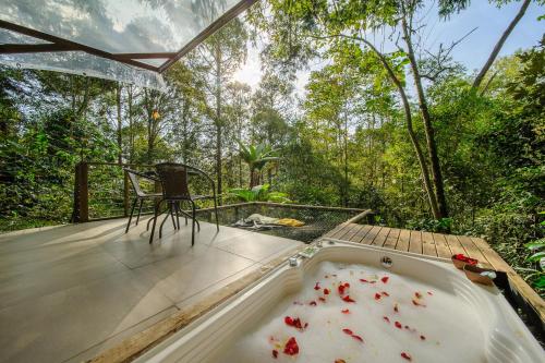 a bath tub on a deck with a chair and trees at TERRAMAGA glamping in San Francisco