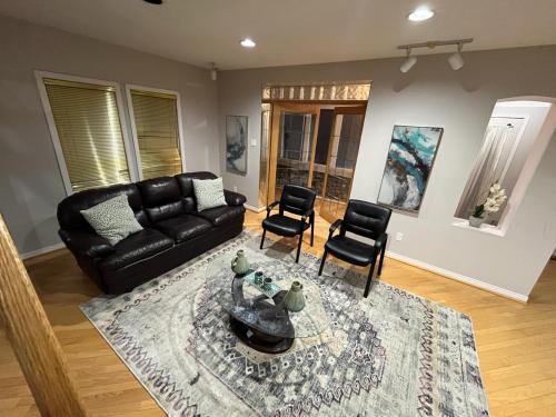 uma sala de estar com um sofá de couro preto e cadeiras em Luxurious Private Room Close to Amenities 25 Min to Downtown Toronto P2b em Pickering