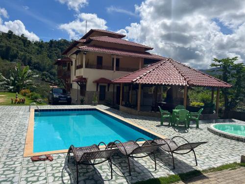 eine Villa mit einem Pool und einem Haus in der Unterkunft Casa de Campo Domingos Martins in Domingos Martins
