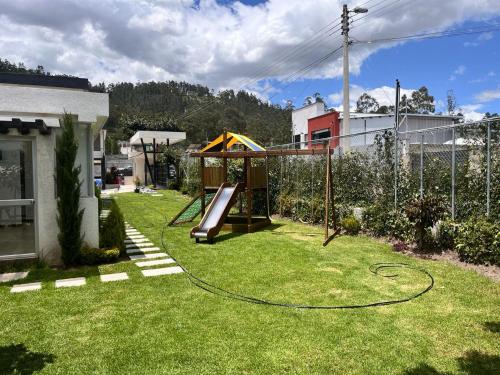 un patio con parque infantil con tobogán en Casa excelente (Llano Chico), en Quito