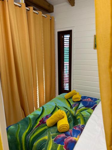two yellow stuffed animals sitting on top of a bed at L'escale Tropicale in Sainte-Anne