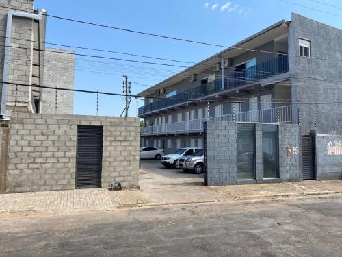 un edificio con coches estacionados en un estacionamiento en Residencial pimenta - aluguel temporada - apto mobiliado en Cuiabá