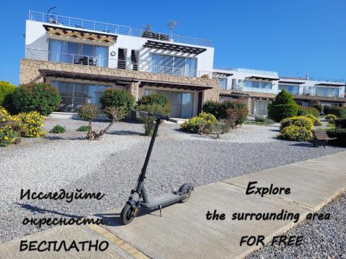 a scooter is parked in front of a house at Sea and Mountain View Beachfront Penthouse in Yalı