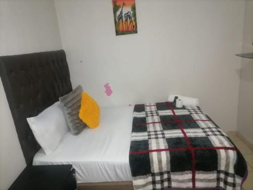 a bedroom with a bed with a blanket on it at Guest room florida in Roodepoort