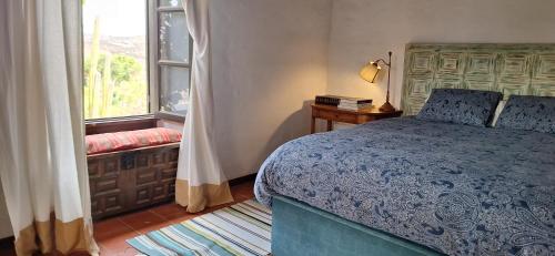 Un dormitorio con una cama azul y una ventana en Casa Jardín de Tiagua, en Tiagua