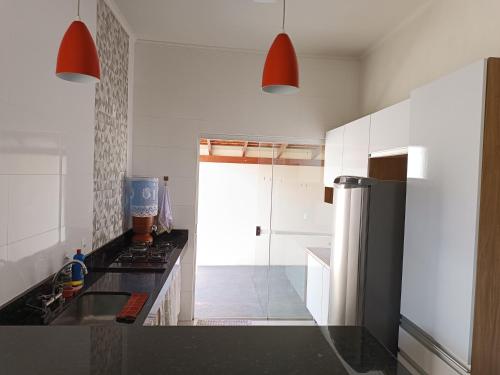 eine Küche mit einer Spüle und einem Kühlschrank in der Unterkunft Casa Flor in São João Batista do Glória
