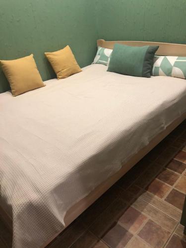 ein großes weißes Bett mit mehreren Kissen darauf in der Unterkunft Apartment near Armenian Cathedral in Lwiw