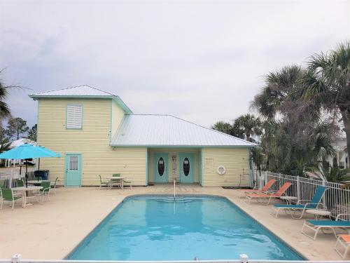 a house with a swimming pool in front of a house at Seaglass @ Orange Beach Villa in Orange Beach