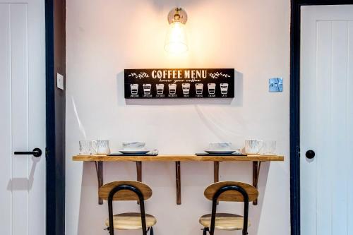 a table with two stools and a sign that reads other new at Stylish Victorian house, close to City Centre in Colchester