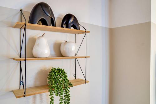 a shelf with vases and a plant on a wall at Stylish Victorian house, close to City Centre in Colchester