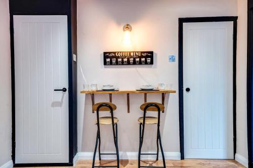 a bar with two stools next to two doors at Stylish Victorian house, close to City Centre in Colchester