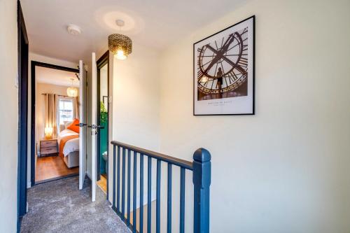 a staircase leading to a bedroom with a clock on the wall at Stylish Victorian house, close to City Centre in Colchester
