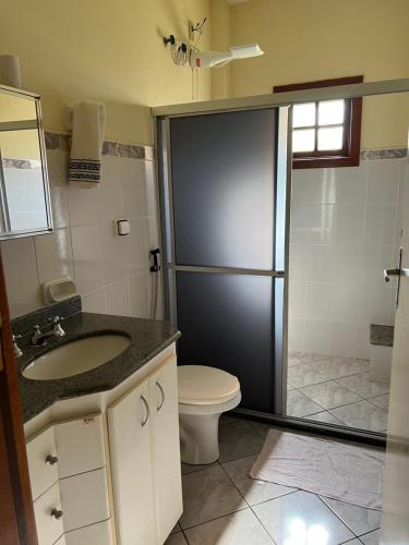ein Bad mit einer Dusche, einem WC und einem Waschbecken in der Unterkunft Casa de Campo Domingos Martins in Domingos Martins