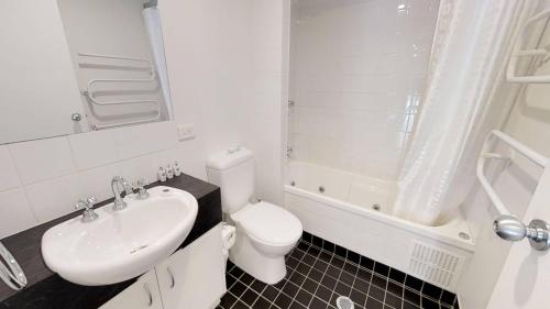 Baño blanco con aseo y lavamanos en Apartment 11 The Stables Perisher, en Perisher Valley