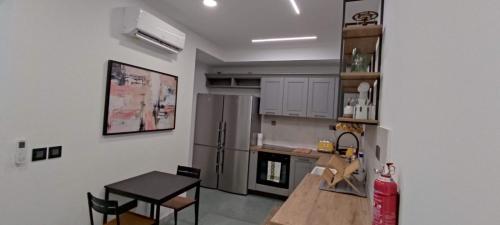 a kitchen with a table and a refrigerator at DAHLIA APARTMENT Paola in Paola