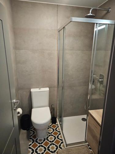 a small bathroom with a toilet and a shower at DAHLIA APARTMENT Paola in Paola