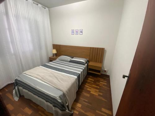 ein kleines Schlafzimmer mit einem Bett und einem Fenster in der Unterkunft Apartamento até 8 pessoas Araxá Ótima localização in Araxá