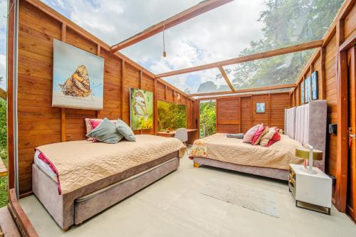 two beds in a room with a large window at TERRAMAGA glamping in San Francisco