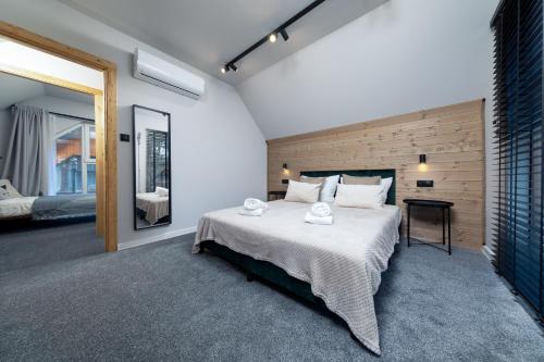 una camera da letto con un letto grande e uno specchio di DOMKI BURSZTYN a Mrzeżyno
