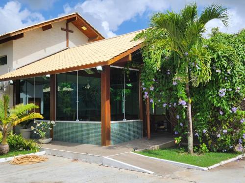 a house with a palm tree in front of it at Eventos Villa Garden in Aracaju
