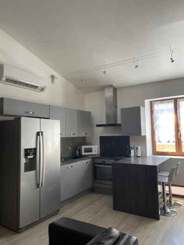 een keuken met een roestvrijstalen koelkast en een tafel bij Chez Tony et Laurie in Montbrun-des-Corbières