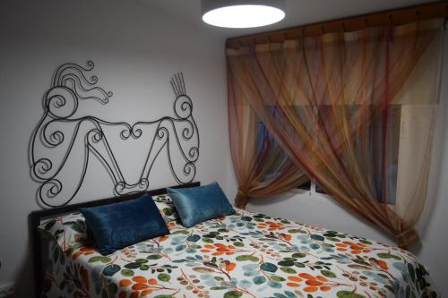 a bedroom with a bed with a decorative head board at LOS TOCHOS in Chiclana de la Frontera