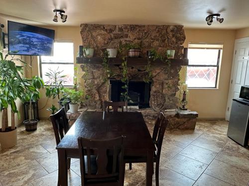 a dining room with a table and a stone fireplace at Matterhorn Inn Ouray in Ouray