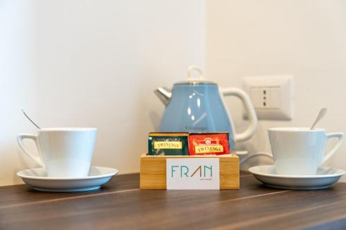 two cups and a tea set on a table with a tea pot at FRAN CITY SUITE in Vico Equense