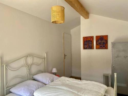 - une chambre dotée d'un lit avec des draps blancs dans l'établissement Maison de vacances pour 2, 6 ou 10 personnes, à Lège-Cap-Ferret