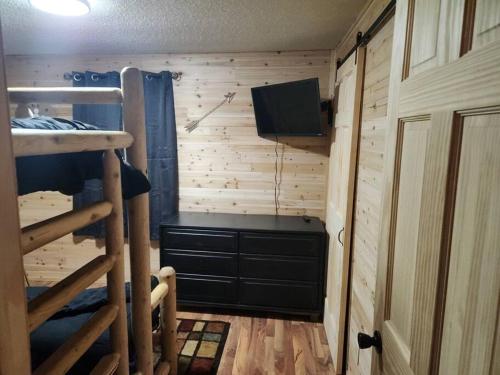 a bedroom with a bunk bed and a television in a room at Close to Munising, Pictured Rocks, ORV access in Shingleton