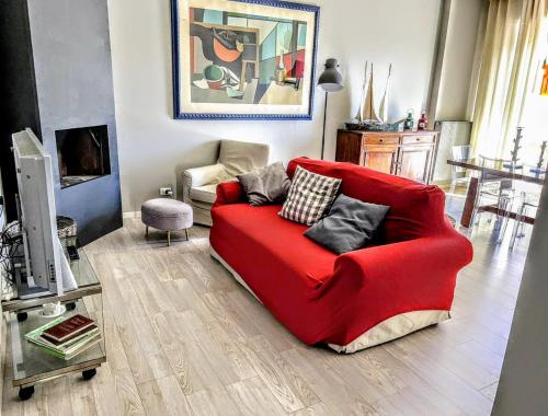 a red couch sitting in a living room at -Penthouse con Terrazza Panoramica -Free Parking- in Carrara