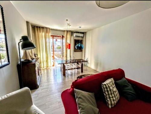 a living room with a red couch and a table at -Penthouse con Terrazza Panoramica -Free Parking- in Carrara