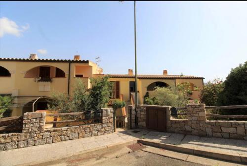a house with a stone wall in front of it at Casa Liberty in Villasimius