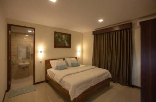 1 dormitorio con 1 cama y baño con ducha en Dawn Golf Villa, en Tanjung