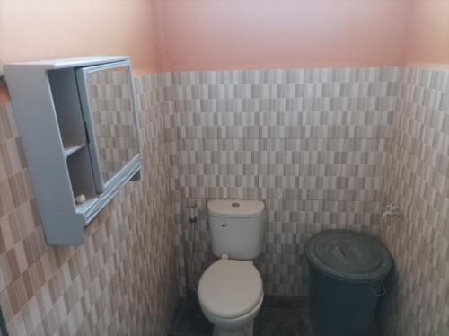 a bathroom with a toilet and a trash can at Nias Shady Palm surfcamp in Lagudri