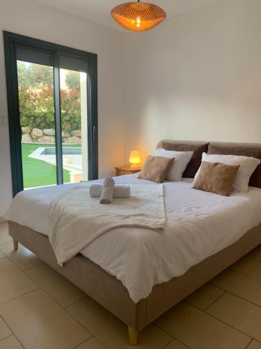 ein großes Bett in einem Zimmer mit einem großen Fenster in der Unterkunft Villa Côté Soleil in Auribeau-sur-Siagne