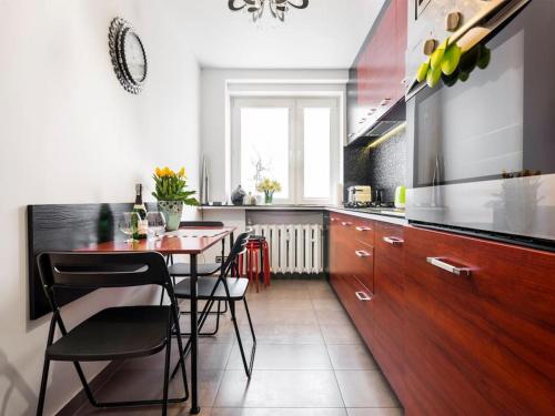 kuchnia ze stołem i krzesłami w kuchni w obiekcie Apartament Kolorowy w Krakowie