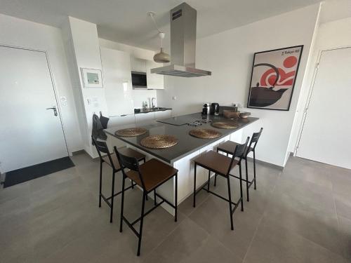 a kitchen with a table and chairs in it at L'Appartement de l'Artiste in Marseillan