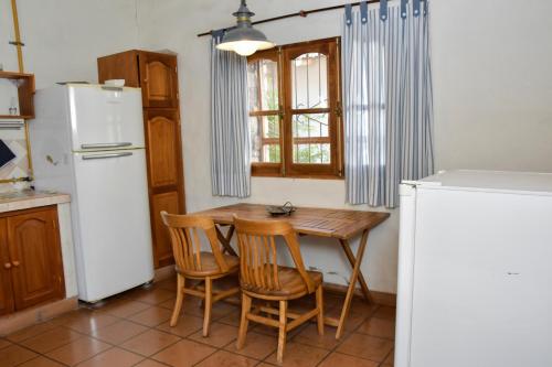 蒂爾卡拉的住宿－Rincon de Sueños，厨房配有桌子、两把椅子和冰箱
