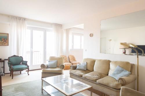 a living room with a couch and a table at Lovely 66 m 2 steps from the city center in Boulogne-Billancourt