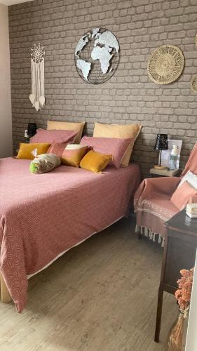 - une chambre dotée d'un grand lit avec des oreillers roses et jaunes dans l'établissement Les trois îles O.Ré.A., à Aytré