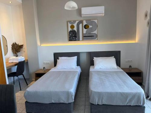 two beds in a room with a table and a desk at Ilias Nest 4 in Kardamaina
