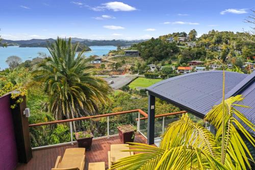 a balcony with chairs and a view of the water at Sanctuary Palms in Paihia